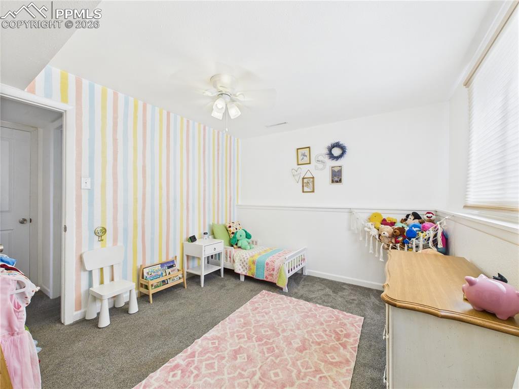 Bedroom featuring dark colored carpet and ceiling fan