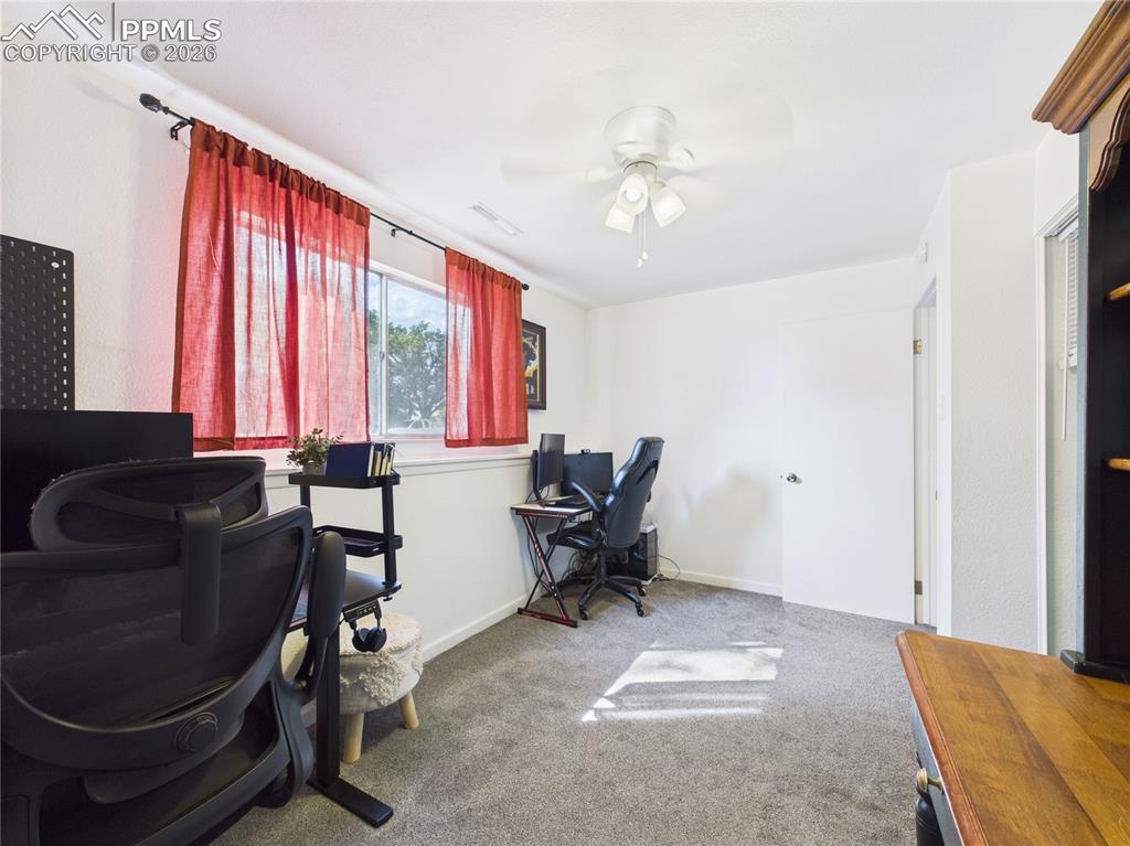 Office area featuring light colored carpet and ceiling fan