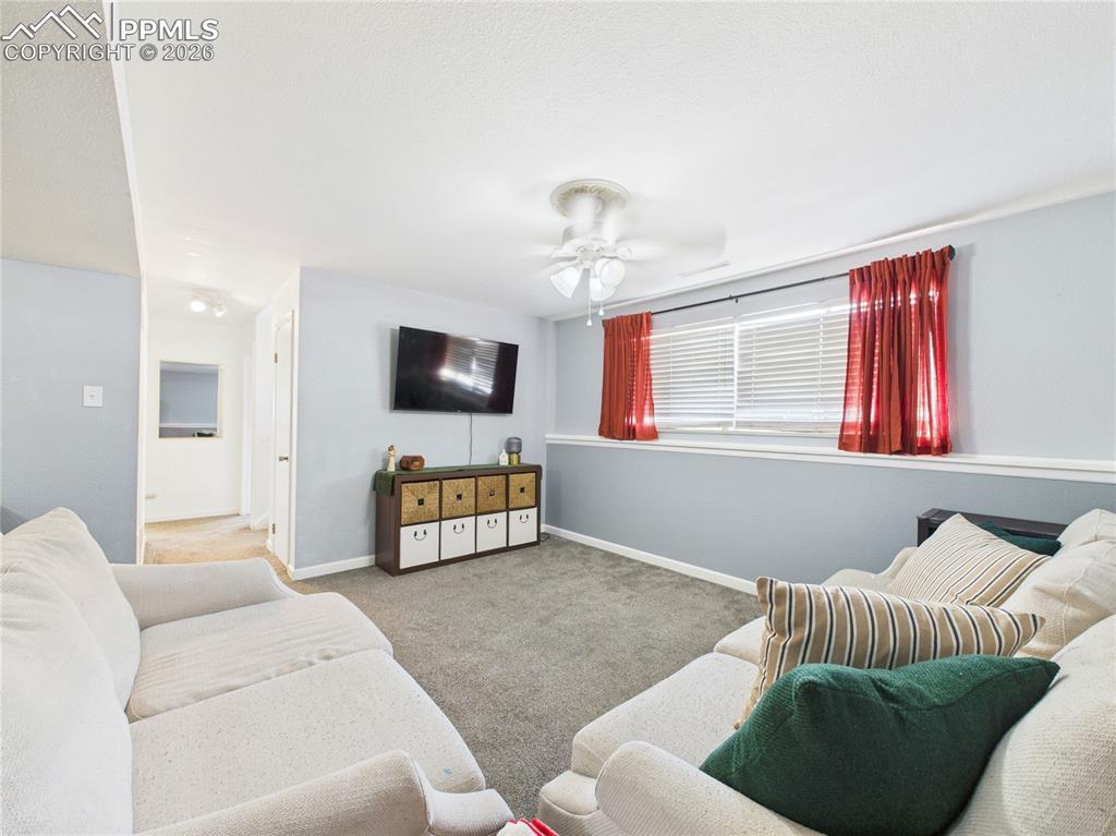 Living area with carpet flooring and ceiling fan