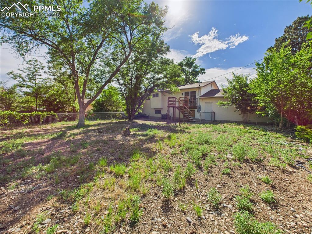 Fenced yard featuring stairs and a deck