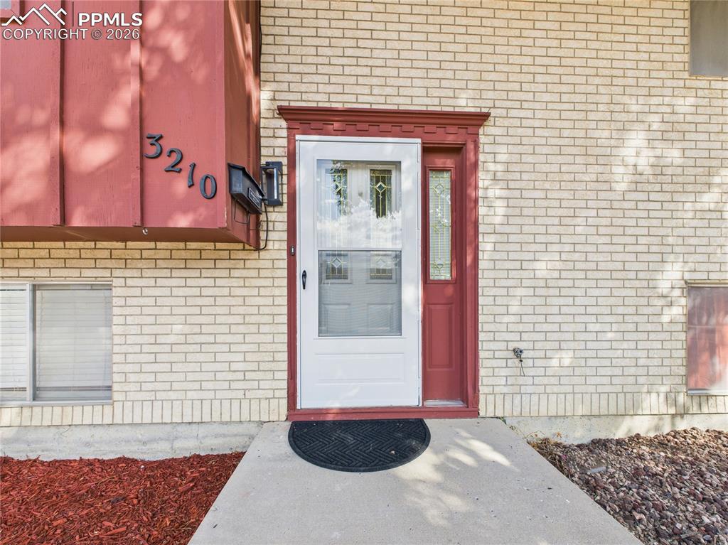 Property entrance featuring brick siding