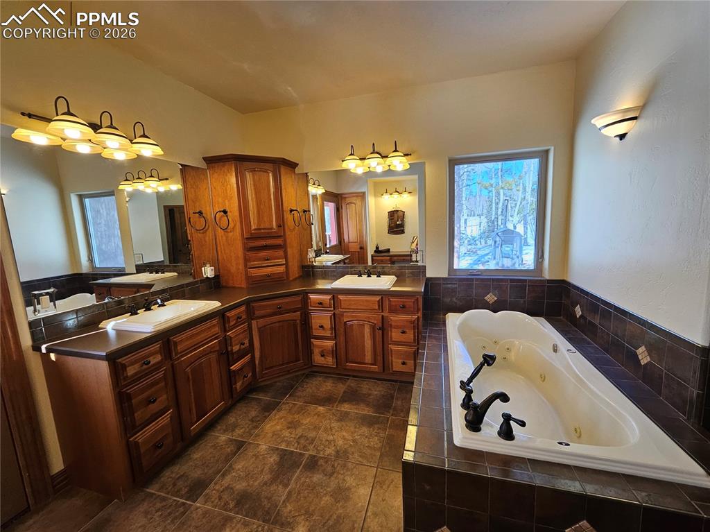 Bathroom featuring a jetted tub and double vanity
