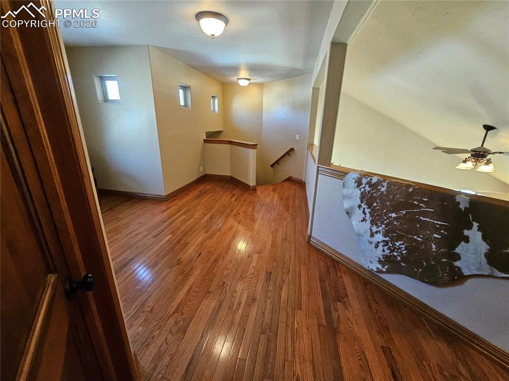 Spacious upstairs landing with hardwood / wood-style flooring