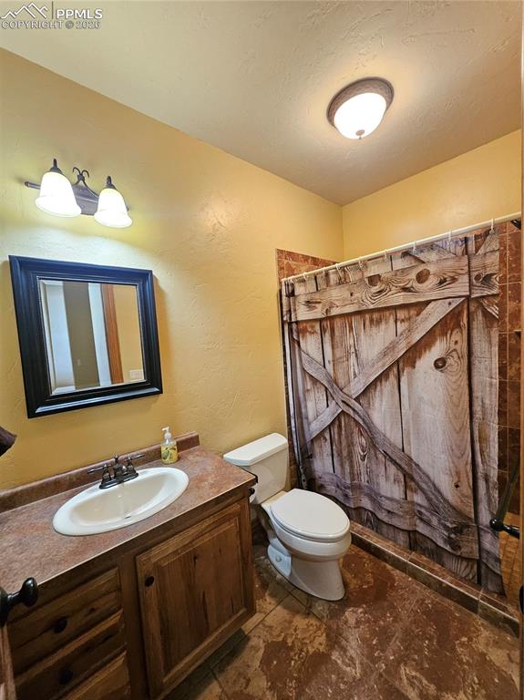 Bathroom in basement with vanity and curtained shower
