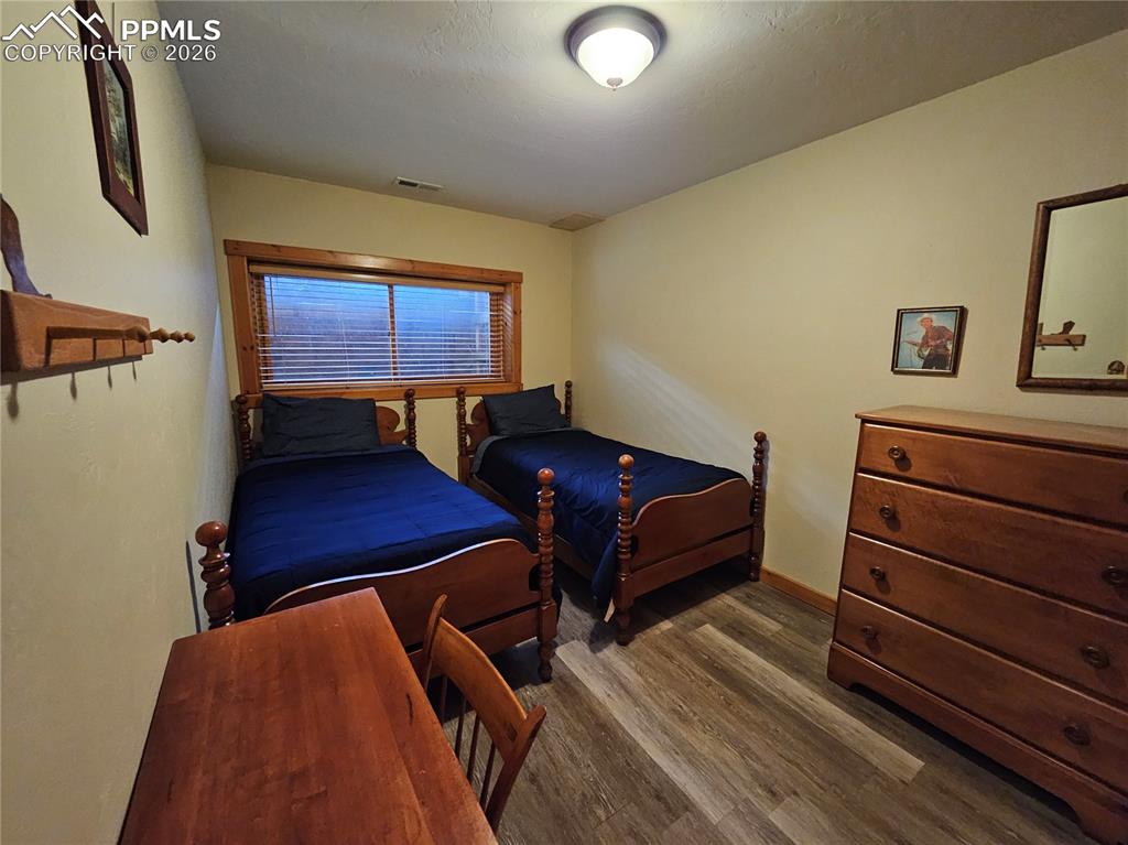Bedroom with dark wood-style floors in cabin basement