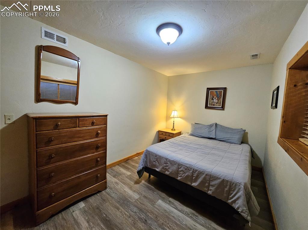Cabin bedroom in basement with wood-style flooring