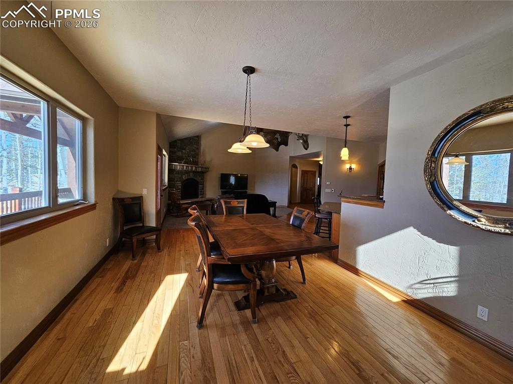 Dining area featuring hardwood / wood-style floors and stone fireplace
