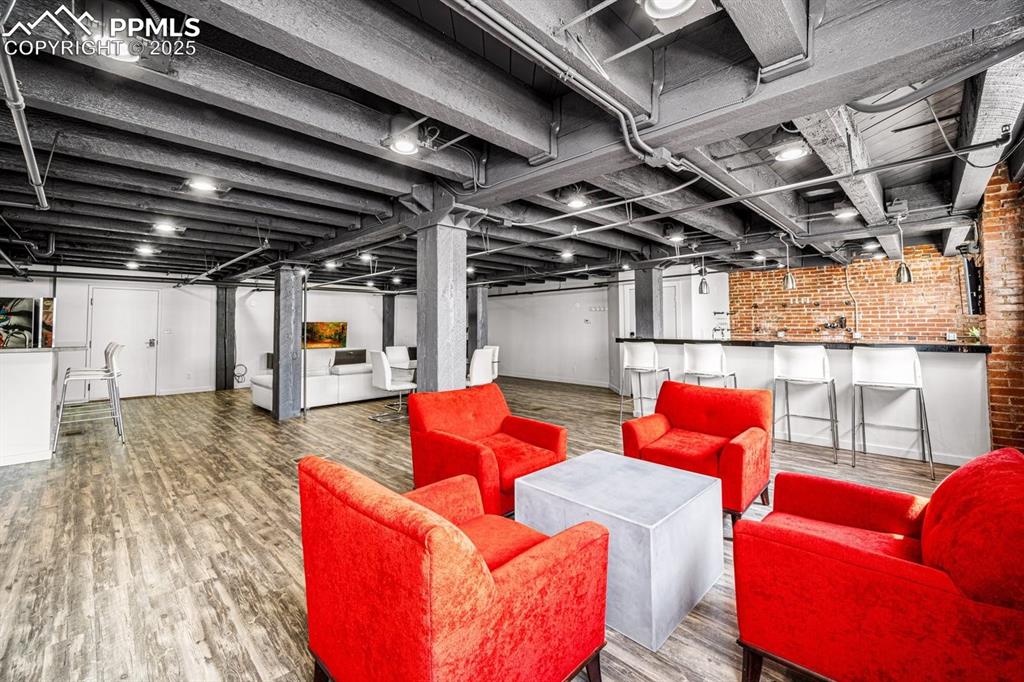 featuring brick wall and wood finished floors