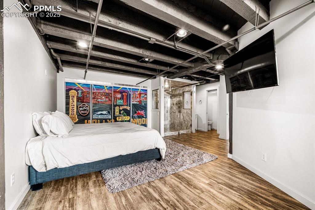 Bedroom with wood finished floors and baseboards