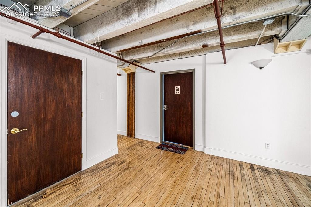 Finished below grade area with baseboards and light wood-style floors