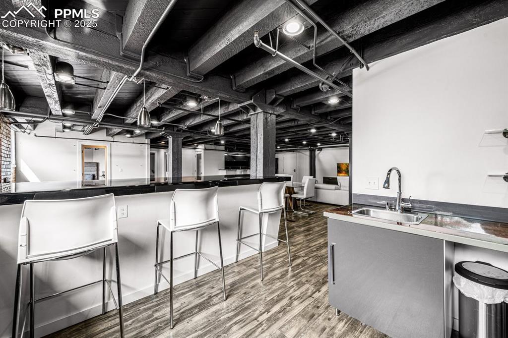 Kitchen featuring wood finished floors, a kitchen breakfast bar, and dark countertops