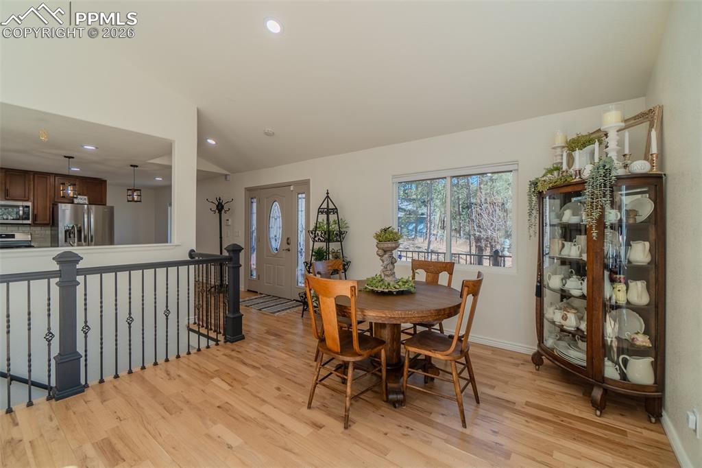 Dining space featuring vaulted ceiling, light wood-style flooring, and recessed lighting