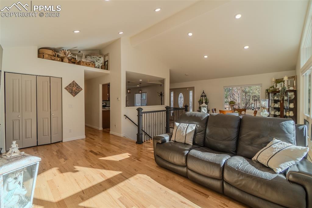 Living area with light wood finished floors, recessed lighting, and lofted ceiling