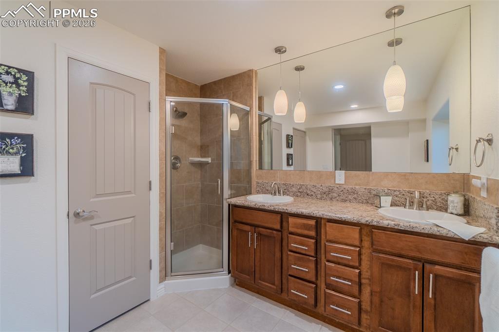 Lower Level Bathroom *Huge* with double vanity, a shower stall, and light tile patterned flooring