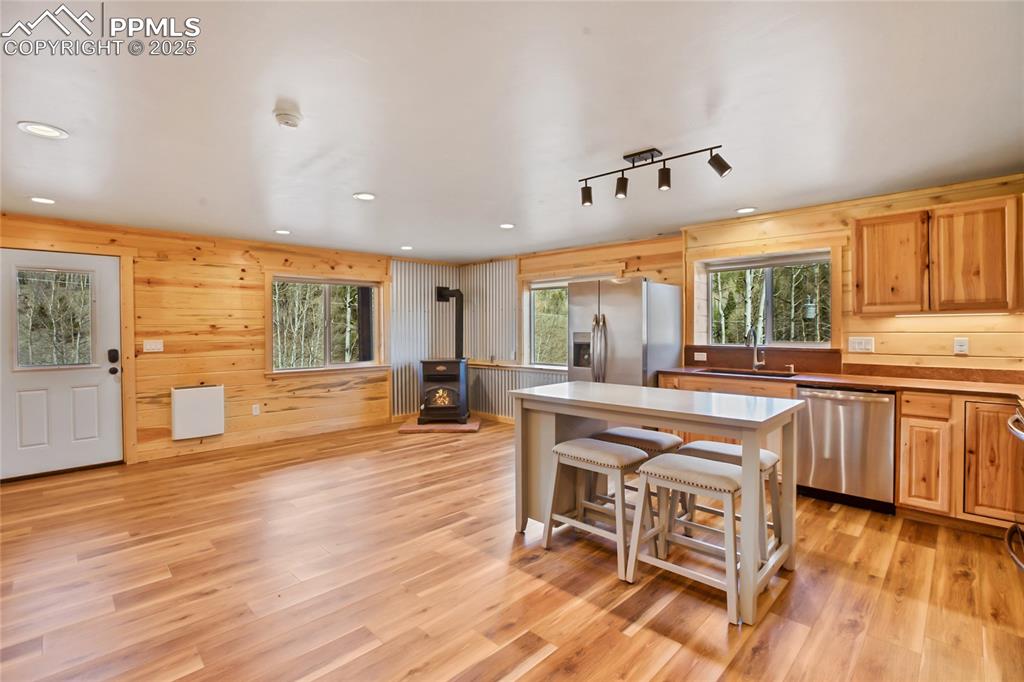 Kitchen with appliances with stainless steel finishes, a wood stove, a sink, plenty of natural light, and recessed lighting