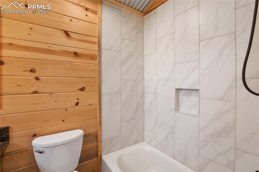 Upstairs Full bathroom featuring toilet, tile bathing tub / shower combination