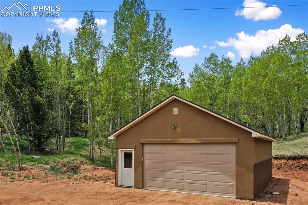 Detached garage featuring a forest view