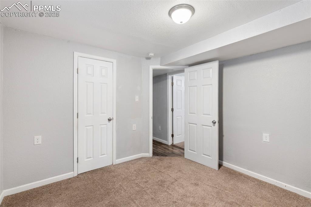 Below grade area with carpet and a textured ceiling