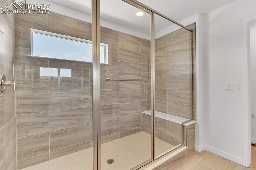Bathroom with a stall shower, light wood-style flooring, and recessed lighting