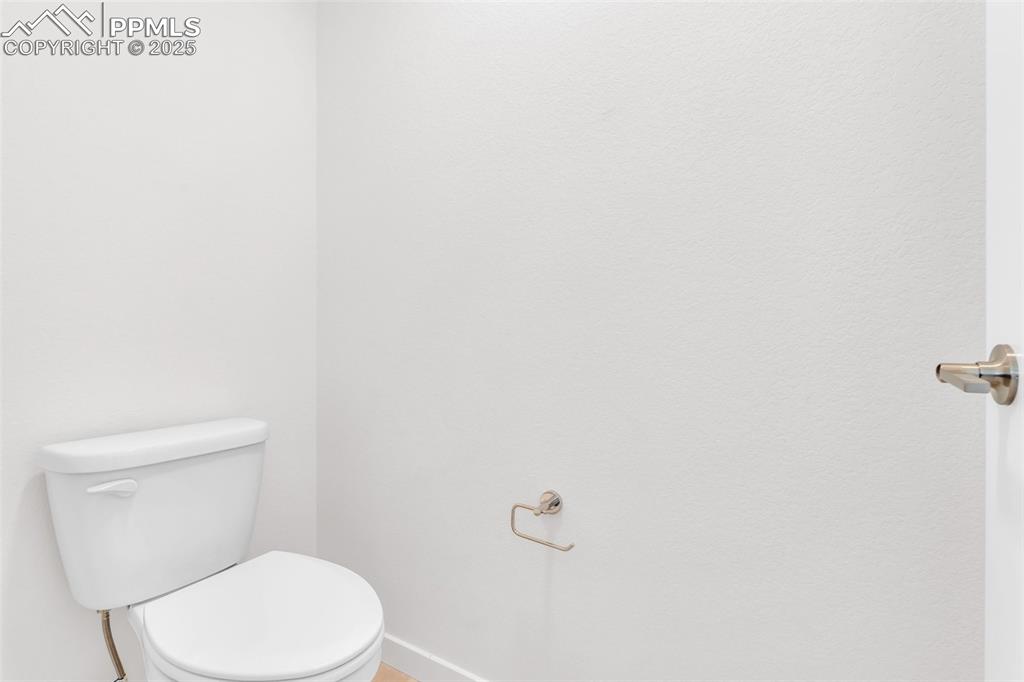 Half bathroom with toilet and baseboards