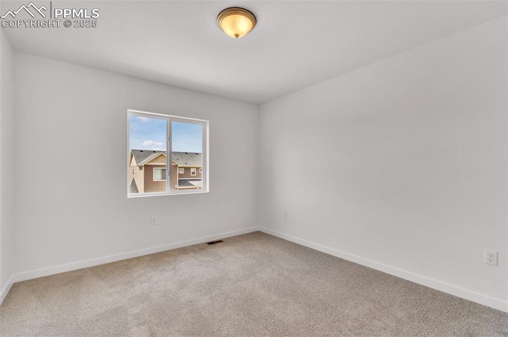 Carpeted empty room featuring baseboards
