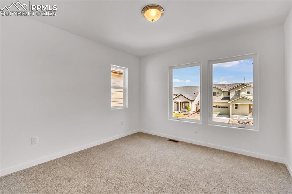 Unfurnished room with light colored carpet and baseboards