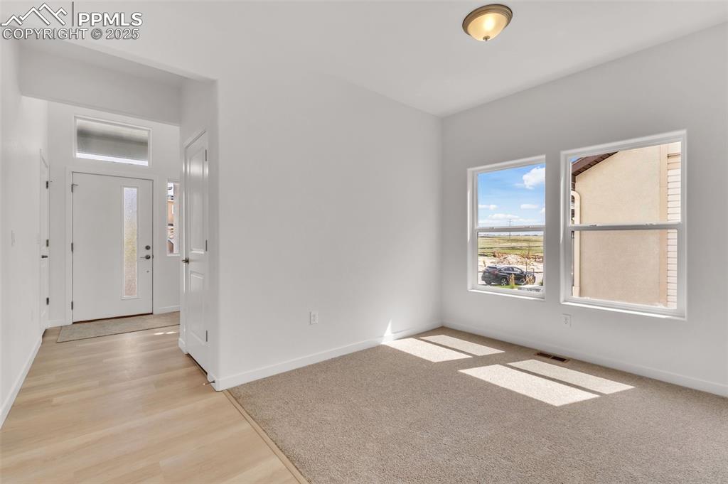 Spare room with light wood-style flooring and light carpet