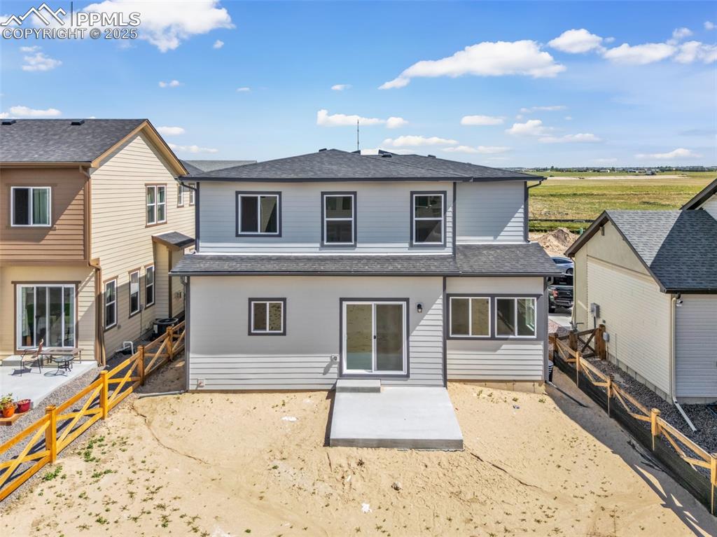 Rear view of property featuring a patio area, a shingled roof, and a fenced backyard