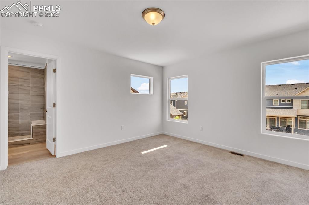 Spare room with light carpet and baseboards