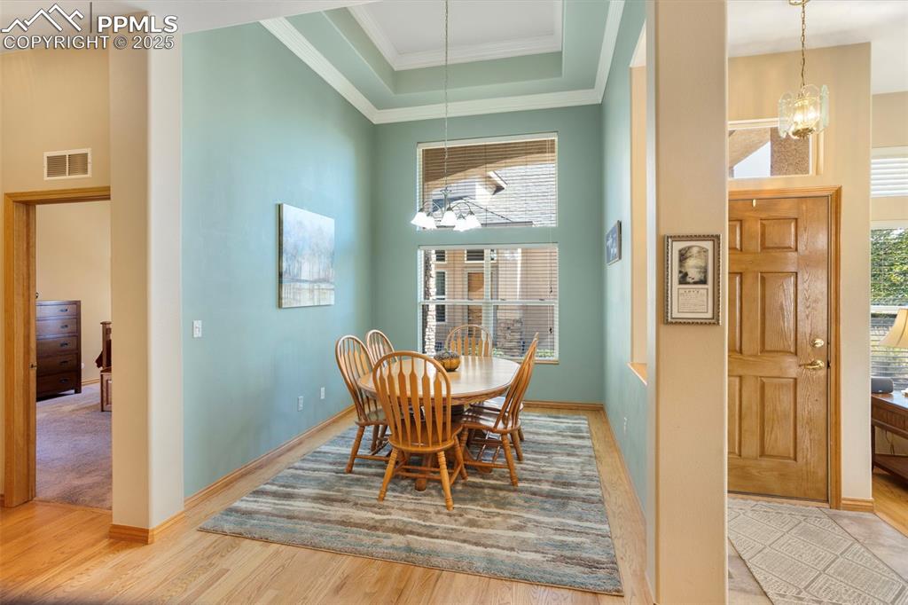 A coffered, cathedral ceiling adds a touch of elegance to the formal dining room. The primary bedroom is to the left of the dining room.