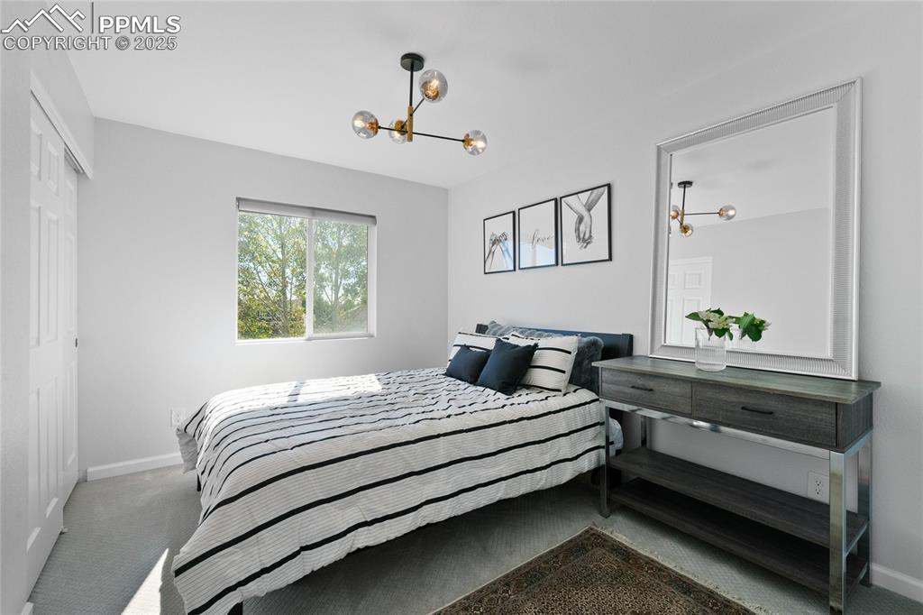 Bedroom with carpet flooring, a chandelier, and a closet