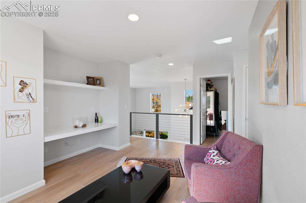 Living area with recessed lighting, light wood-type flooring, and a chandelier