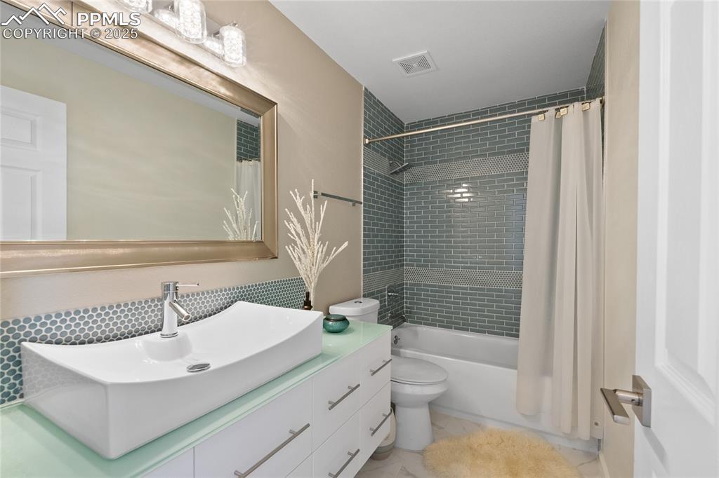 Full bathroom with shower / bath combination with curtain and vanity