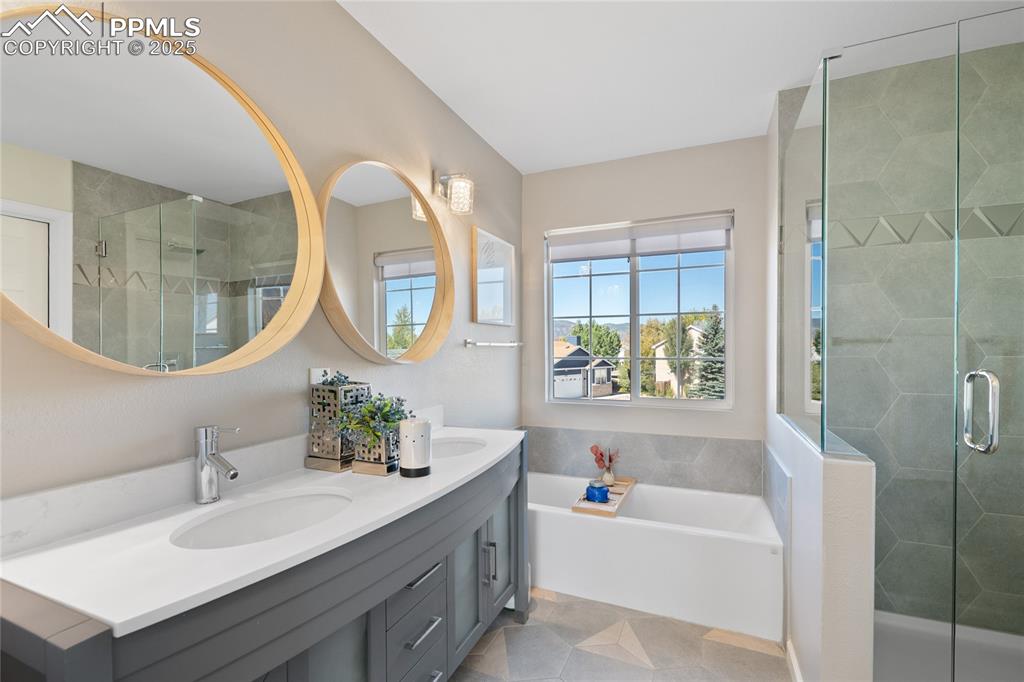 Full bath featuring a garden tub, a shower stall, and double vanity