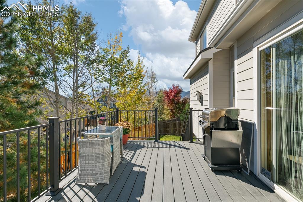 Wooden deck featuring area for grilling and outdoor dining area