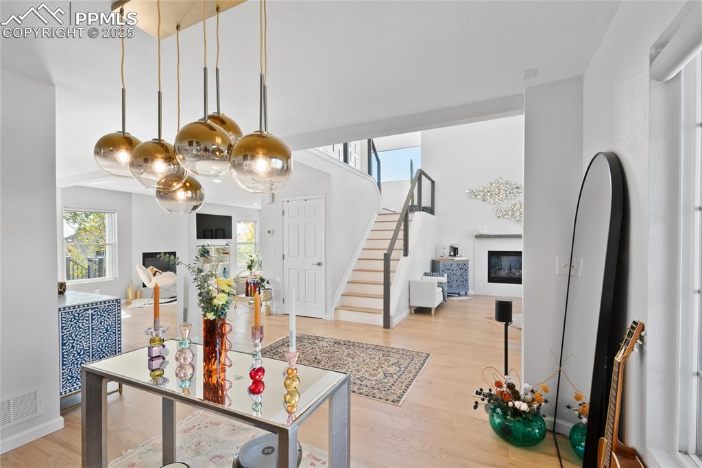 Entrance foyer with healthy amount of natural light, a glass covered fireplace, and light wood-type flooring