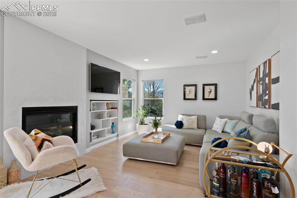 Living area featuring wood finished floors, a fireplace, and recessed lighting