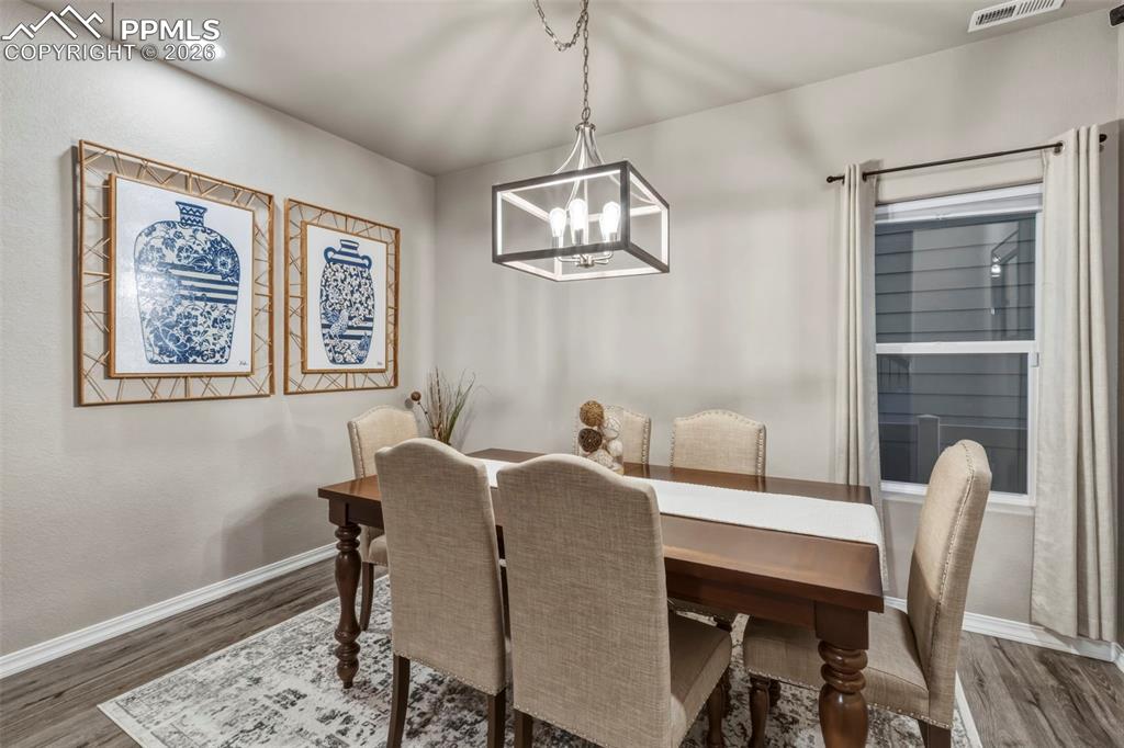 Dining room with wood finished floors and a chandelier