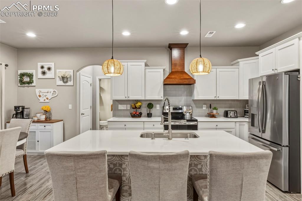 Kitchen featuring stainless steel appliances, light wood-style floors, and white cabinetry