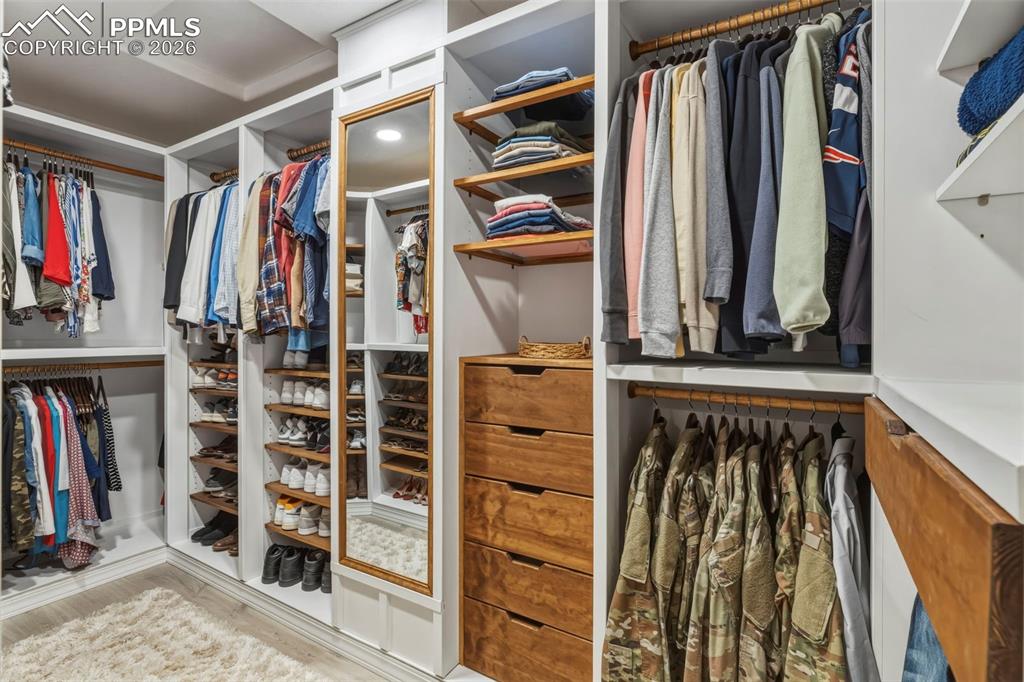 Walk in closet with light wood finished floors