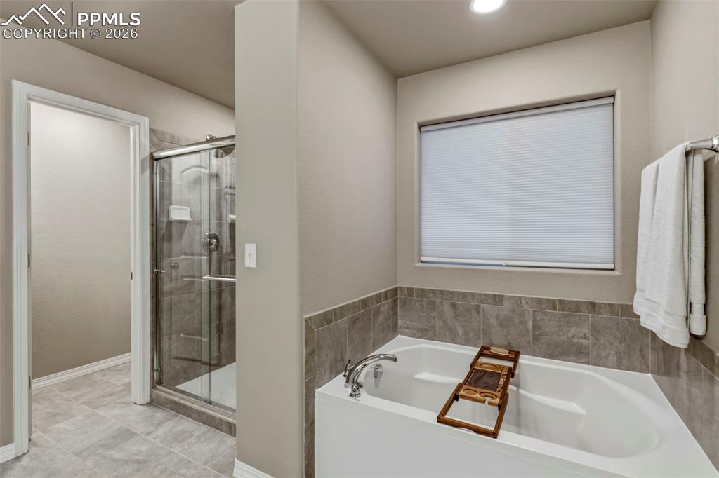 Bathroom featuring a bath and a shower stall