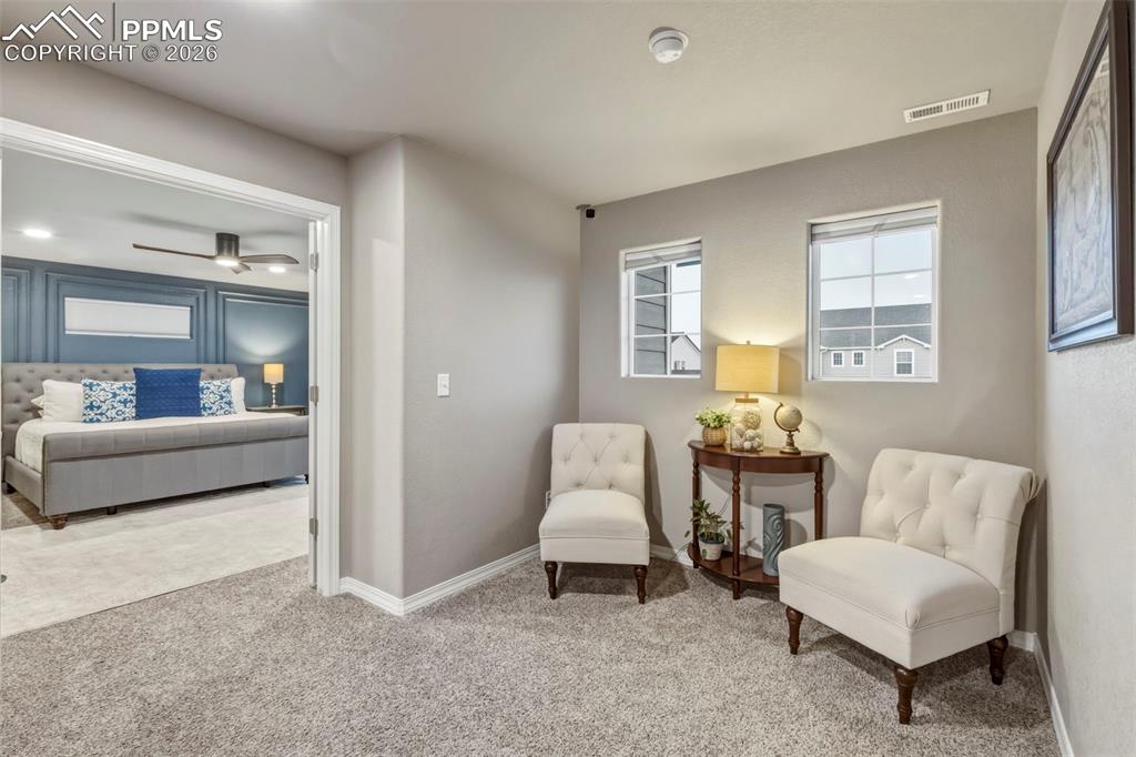 Living area featuring carpet flooring and baseboards