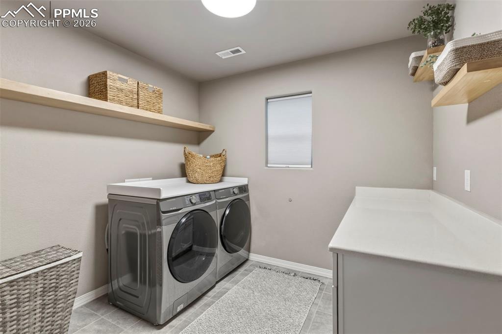 Laundry room featuring baseboards and washing machine and dryer
