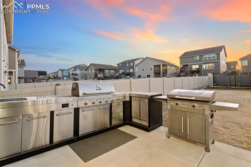 View of patio with a residential view and an outdoor kitchen