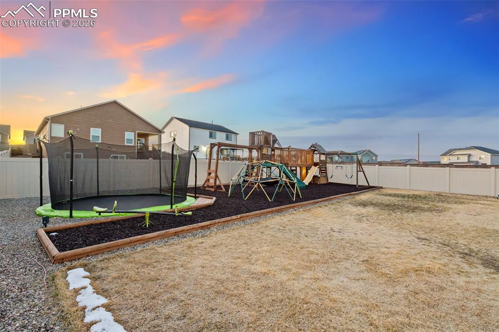 View of play area featuring a residential view, a fenced backyard, and a trampoline