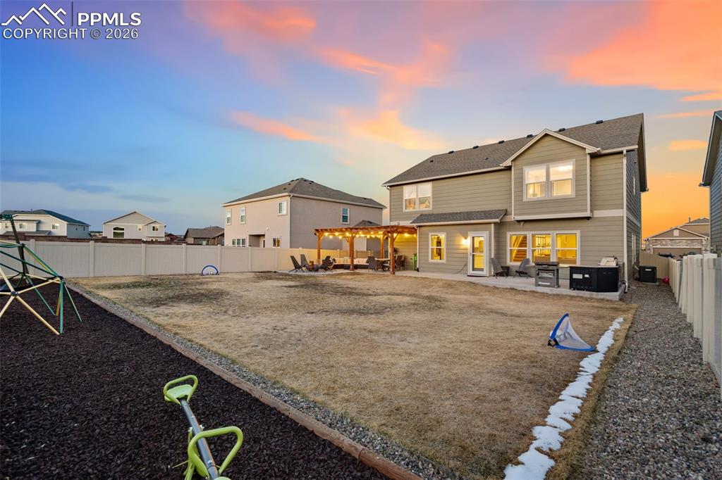 Rear view of house featuring a patio, a fenced backyard, a pergola, and a residential view