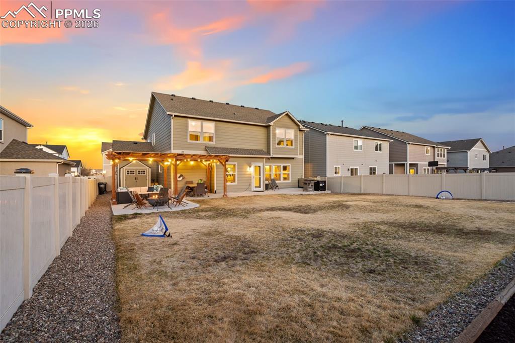 Rear view of house featuring a patio, a fenced backyard, and a residential view