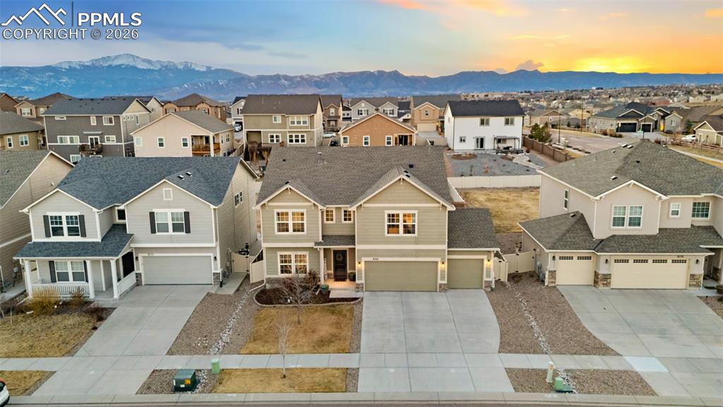 View of front of property featuring concrete driveway, a residential view, a mountain view, and an attached garage