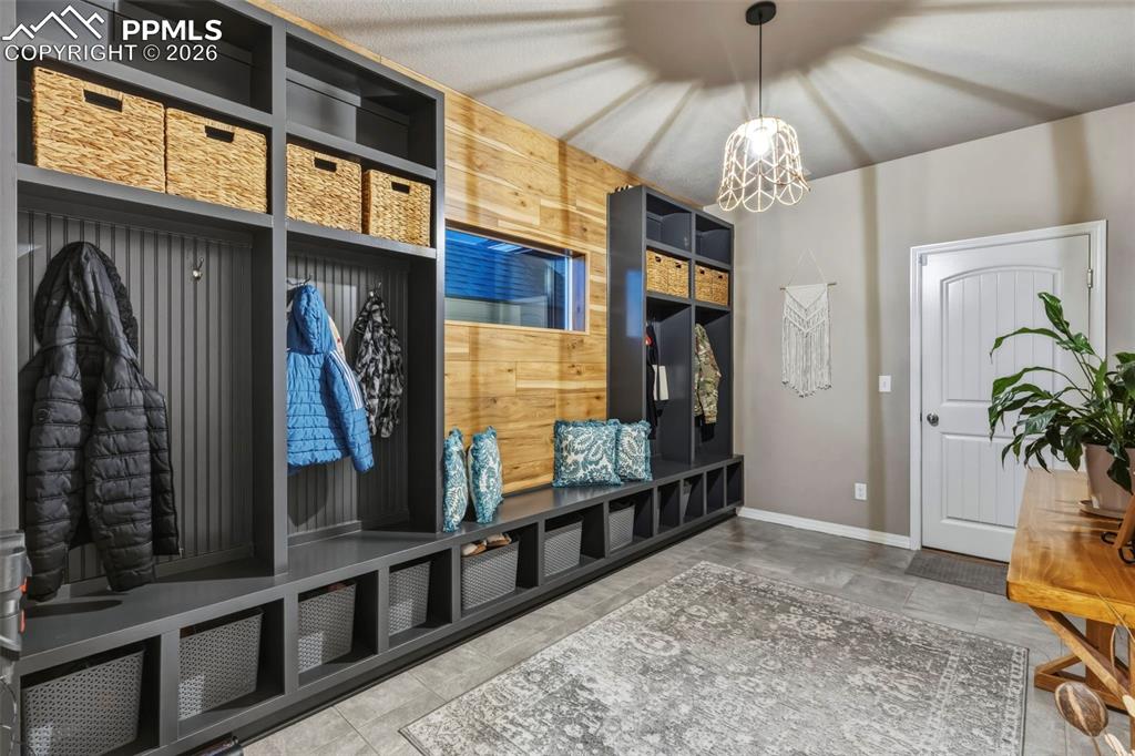 Mudroom featuring baseboards and suspended lighting