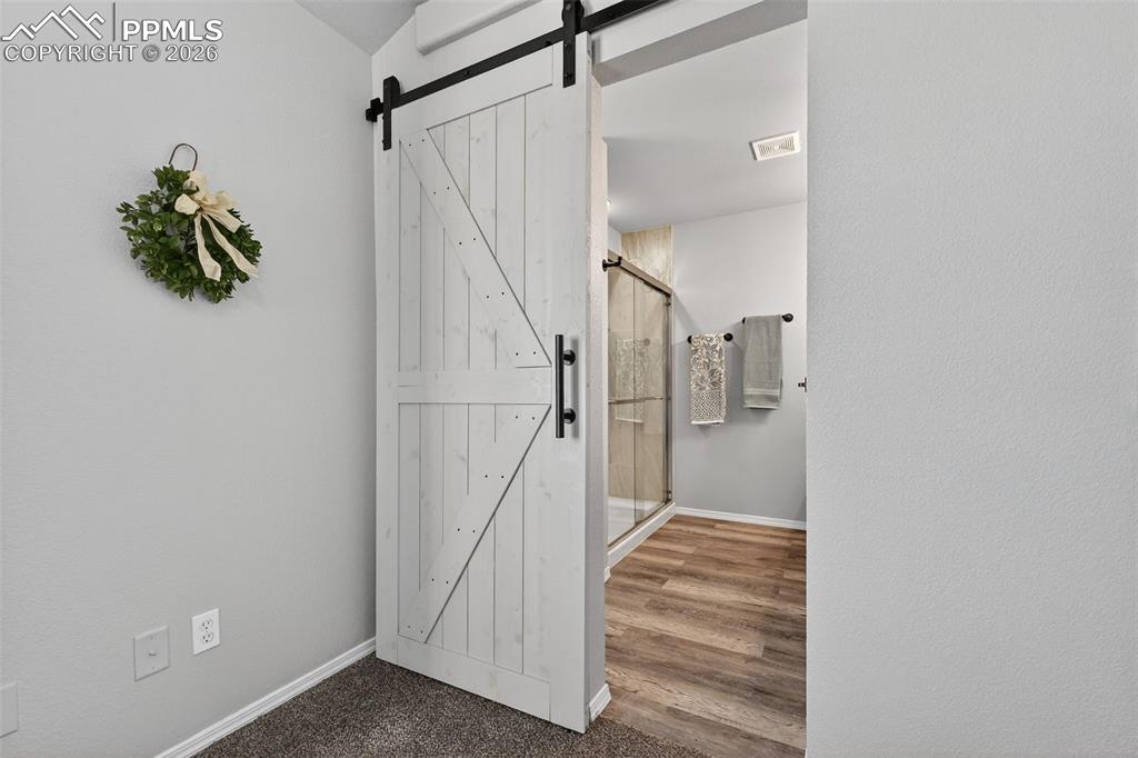 A barn door entry into the primary bathroom.